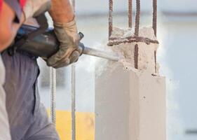 Breaking reinforced concrete with jackhammer photo