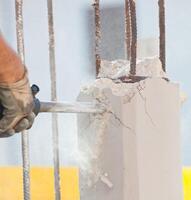 Breaking reinforced concrete with jackhammer photo