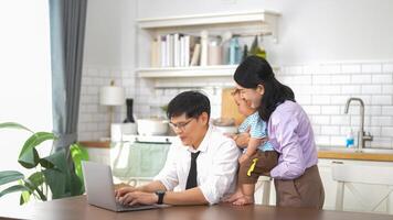 A man and woman are sitting at a table with a laptop photo