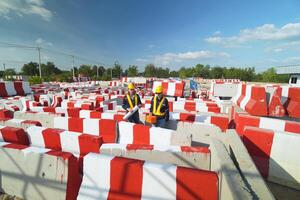 A construction site with workers standing in front of a wall photo