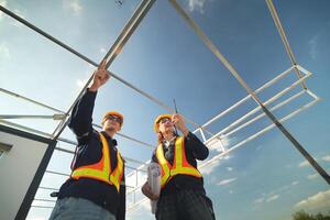 Two surveyor of construction engineer, architect, in hardhat working on construction site. photo