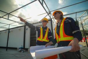 Two surveyor of construction engineer, architect, in hardhat working on construction site. photo