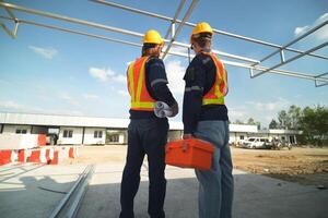 Two surveyor of construction engineer, architect, in hardhat working on construction site. photo