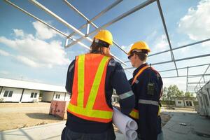 Two surveyor of construction engineer, architect, in hardhat working on construction site. photo