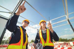 Two surveyor of construction engineer, architect, in hardhat working on construction site. photo