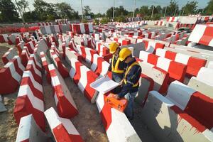 Two surveyor of construction engineer, architect, in hardhat working on construction site. photo