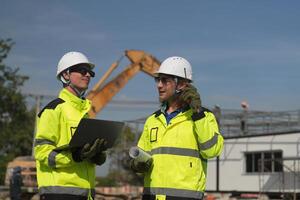Two surveyor of construction engineer, architect, in hardhat working on construction site. photo