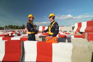 Two surveyor of construction engineer, architect, in hardhat working on construction site. photo