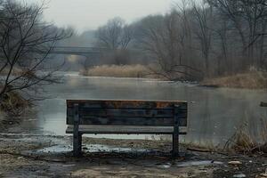 Tranquil Winter Scene with Frozen River and Rustic Bench in Misty Park photo