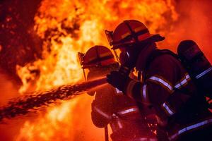 Firefighters Battling Flames with Determination in Intense Firefighting Scene for Emergency Services Awareness photo