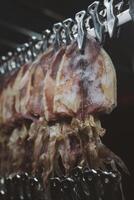 Dried squids, orderly clipped and hanged on metal wire photo