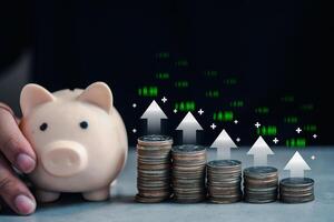 Percentage icon on arrow rising on coin stacks as graph steps near cute pink piggy bank. Coins stack arranged as a graph. photo