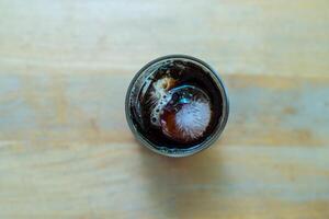Cold refreshment black coffee with ice in glass view on top photo