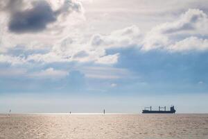 A boat is out in the ocean with a cloudy sky photo