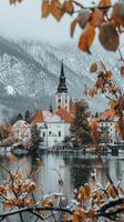 A church in the snow with trees and mountains in the background photo