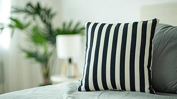 A black and white striped pillow on a bed photo