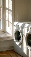 a modern white laundry room interior featuring a washing machine and dryer, with a window positioned on the left side. photo