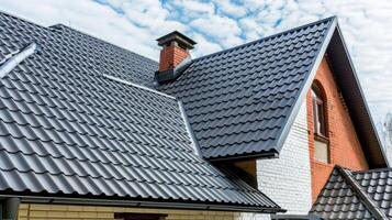 a house featuring black metal roof tiles with gable decoration, showcasing new modern architecture against an isolated background. photo