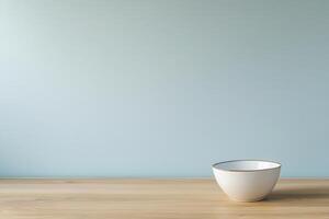 A simple bowl on a wooden table against a blue wall. photo