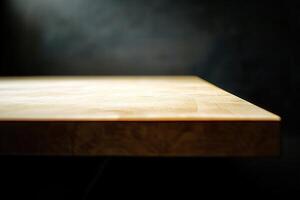 Close-up of a wooden table edge with a dark background. photo
