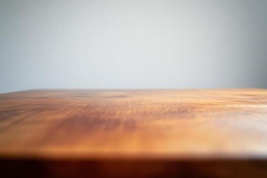 Close-up of a wooden table surface with a plain background. photo