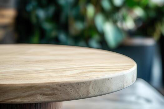 Close-up of a wooden table surface with greenery backdrop. photo