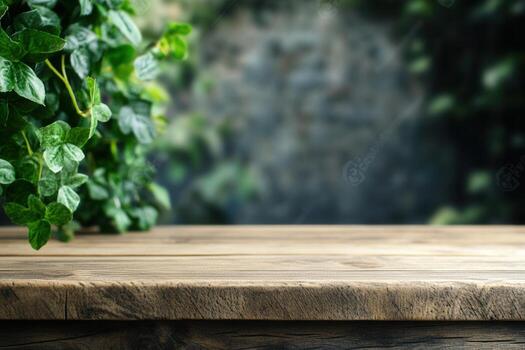 Wooden table with greenery in a blurred background. photo