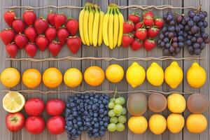 Colorful arrangement of fresh fruits on rustic wood background. photo