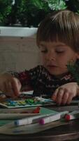 Vertical . Small boy making Christmas greeting cards. Child showing a handicraft made for Christmas. video