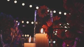 Beautiful candle scene with warm bokeh and white flowers for peaceful ambiance. An elegant candle scene with delicate white flowers and a soft, calming background. video