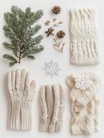 Cozy winter accessories like gloves and a scarf, enhanced with snowflakes and pinecones, create a festive atmosphere on a white backdrop. photo