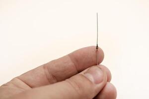 A radio element in your hand. A zener diode. photo