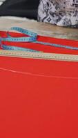 Fashion design workshop. View of woman making pattern on red piece of material Vertical video