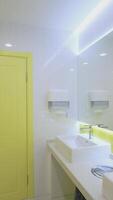 Modern toilets in clinic. White and yellow sterile water closet with wash basins in the hospital. Hygiene during quarantine. Vertical video