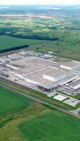Manufacturing on green nature background. Modern industrial territory surrounded by beautiful nature environment. View from above. Vertical video