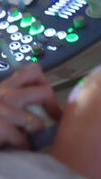 Ultrasonic diagnostics for a pregnant lady. Big round abdomen being checked by the device in doctor's hand. Close up. Vertical video