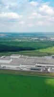 Panoramic view of industry in the countryside. Factory on green field. Industrial plant on nature background. Aerial view. Vertical video