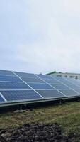 Innovative photovoltaic panels on the field. Sunny batteries on the ground in the modern solar farm. Renewable source of energy. Vertical video