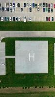 Parking spaces on greenfield. Territory of a plant with car parking. Top view. Camera moves down. Vertical video