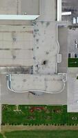 Grey roof of a large plant. Exterior of a factory with parking spaces. industry on field. Camera rising. Top view. video