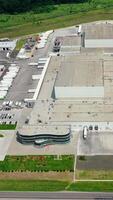 Modern manufacturing on field. Industrial zone with many parking places with trucks on them at a sunny daytime. Motion camera to the left. Aerial view. Vertical video