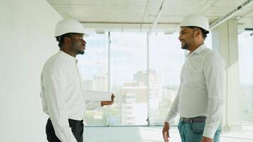 African and Indian builders shaking hands on construction site. Handshake of partner video