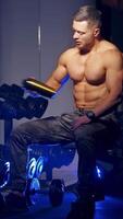 Man spending time in gym. Bodybuilder having rest after heavy deadlifts in modern fitness center. Vertical video
