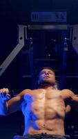 Bodybuilder working out in gym. Strong man during exercise with work out program for healthy. Vertical video