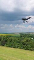 Electric drone flies in the sky. Drone quad copter with high resolution digital camera in the sky. Vertical video