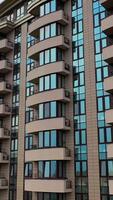 Typical apartment building in urban area. Aerial view of facade of modern high rise multi storey apartment building. Vertical video