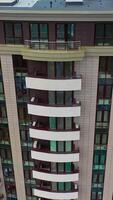 Futuristic architecture cityscape view. Aerial view of facade detail of modern high-rise apartments building. Vertical video