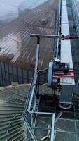 Metal passages between the huge tanks of grain elevator. Number of granary elevator cisterns standing close to each other at agribusiness plant. Vertical video