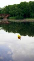 Toy boat of paper in the water. View of paper boat floating in the water. Vertical video