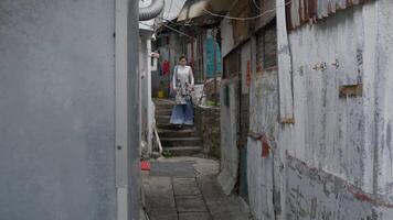 A girl walks down a corridor in the slums of Hong Kong video
